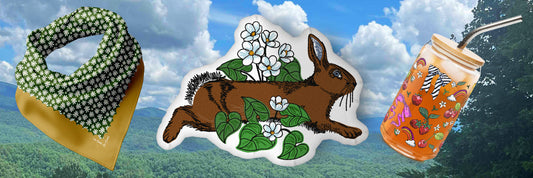 A landscape photo of the Great Smoky Mountains with three Posh Pad products overlaid. The products are the Daisy Bandana, The Rabbit Meadow Shaped Pillow, and the Bows and Berries Can-shaped Glass.