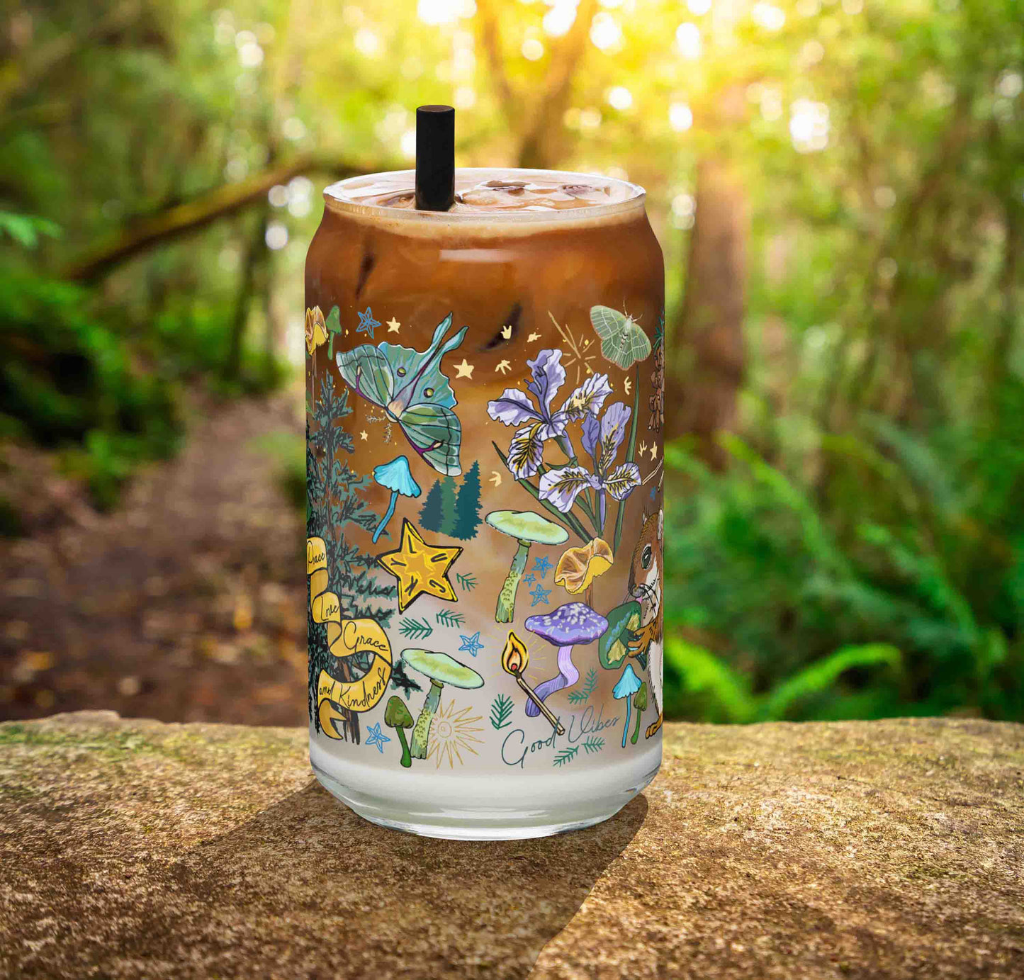 This is a photo of the glass containing an iced latte. It's sitting on a rock in the woods.