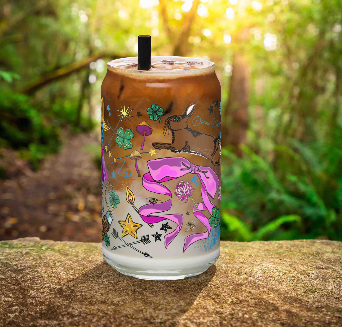 This is a photo of the glass containing an iced latte. It's sitting on a rock in the woods.