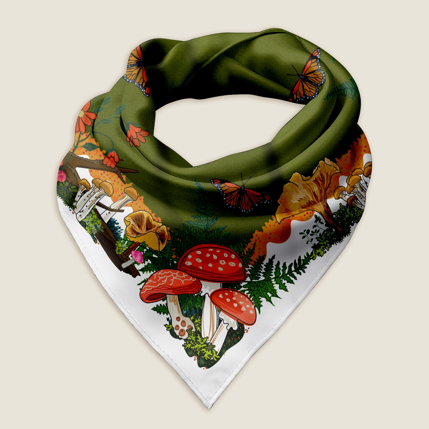 The red mushroom bandana on an ivory background shows the details of the hand-drawn artwork, which includes a variety of red, pink, and yellow mushrooms, butterflies, ferns, red flowers, and moss illustrated around a green middle with a white border.