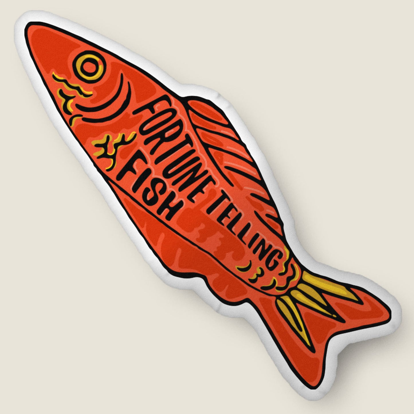 Fortune telling fish-shaped pillow on an ivory background.