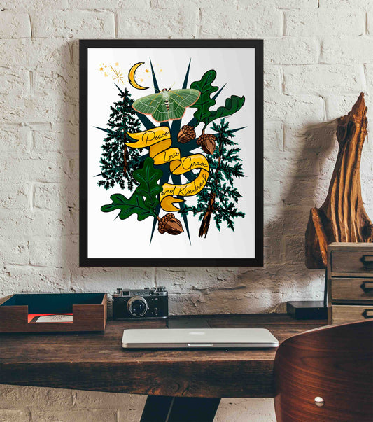 This photo shows the framed Crescent Moon & Moth art print hanging on a white brick wall. Below it, there is a wood. The desk has a camera, laptop, and wood sculpture on it.