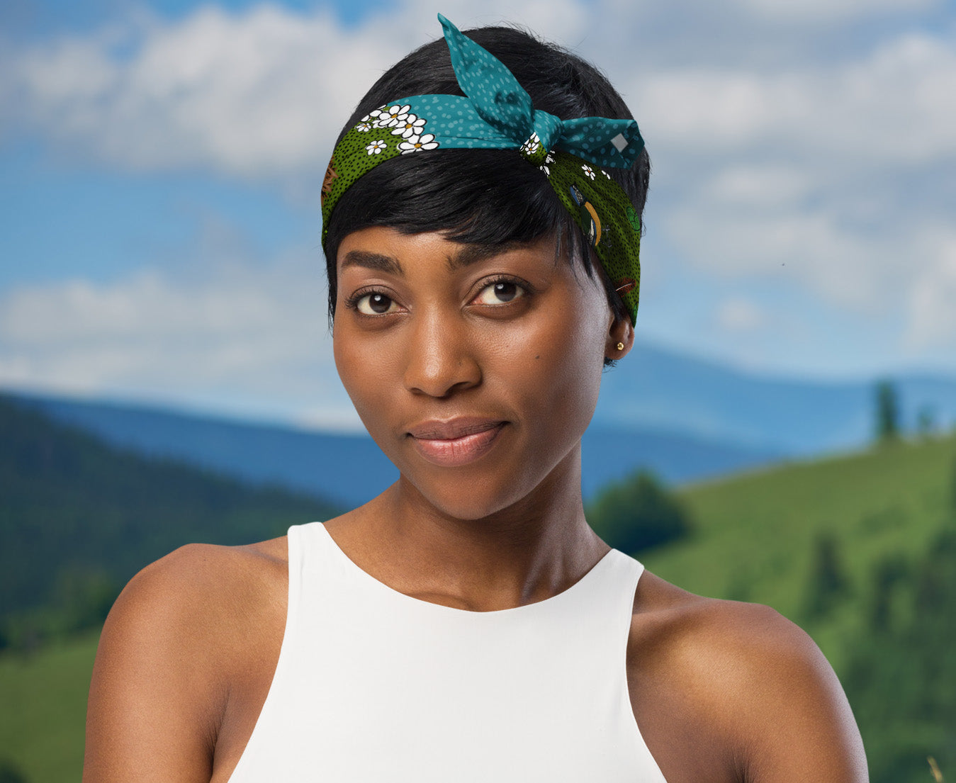 This is an image of a woman wearing the bandana as a headband. There is a mountain view behind her.