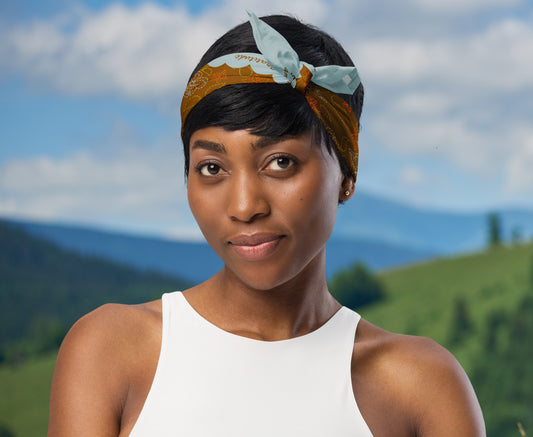 This is an image of a woman wearing the bandana as a headband. There is a mountain view behind her.