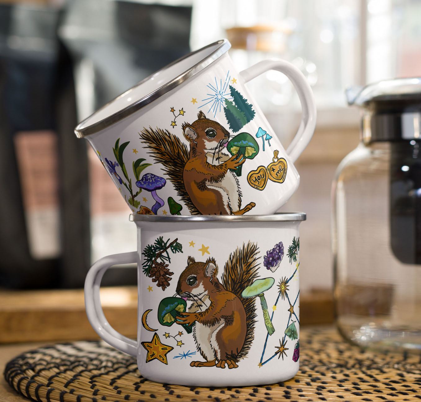 This is a photo of the Cygnus Stars enamel coffee mugs stacked on a kitchen counter sitting beside a coffee pot and bags of coffee.