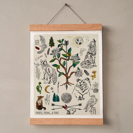 Fierce, Feral, and Free art print poster hung in a wooden wall hanger. The artwork has bears, wolves, birds, forest, a full moon, a crescent moon, crossed arrows, mushrooms, burning sage, and a camp knife.