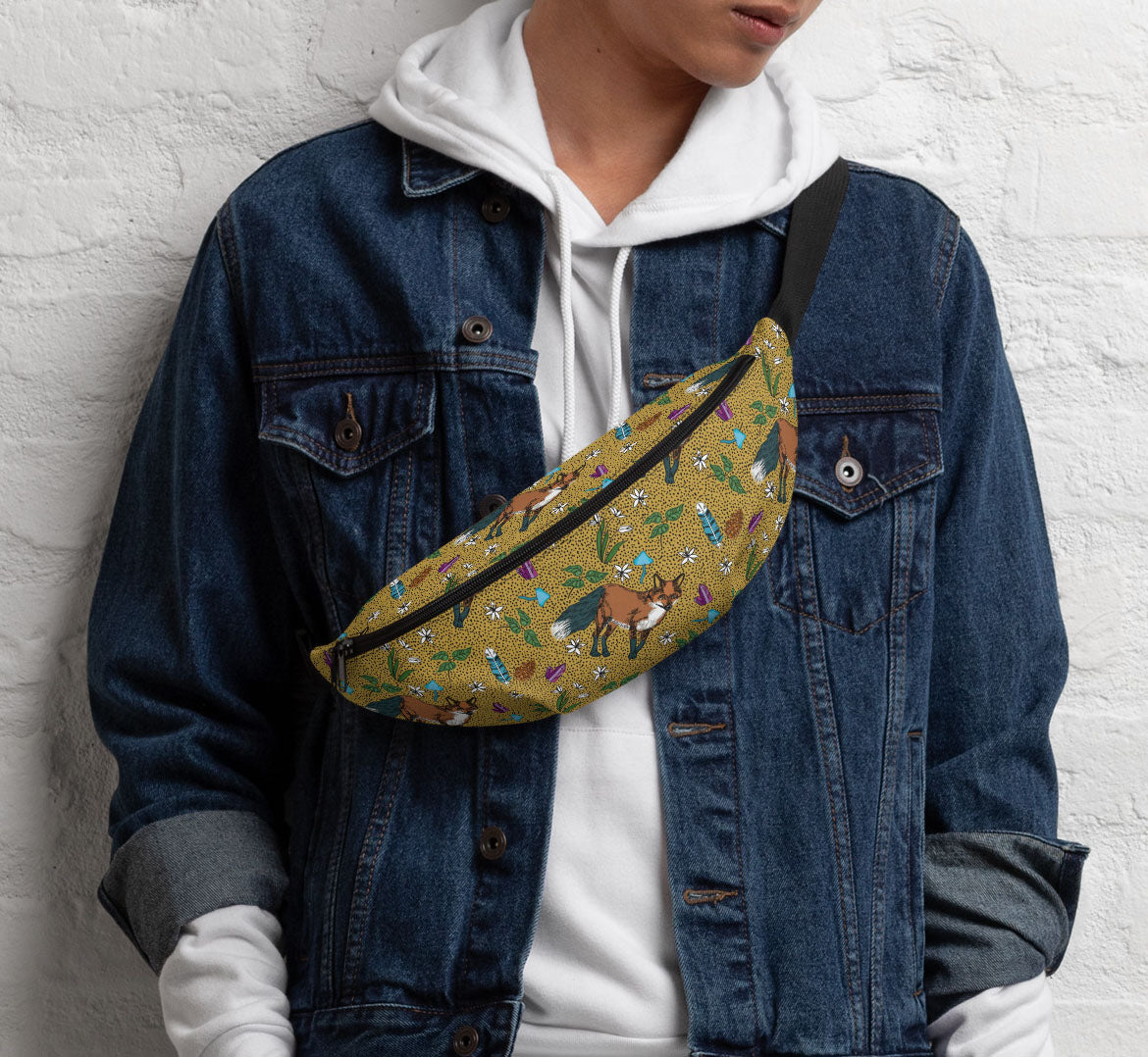 Pack worn in a sling bag style over a denim jacket and a white hoodie.