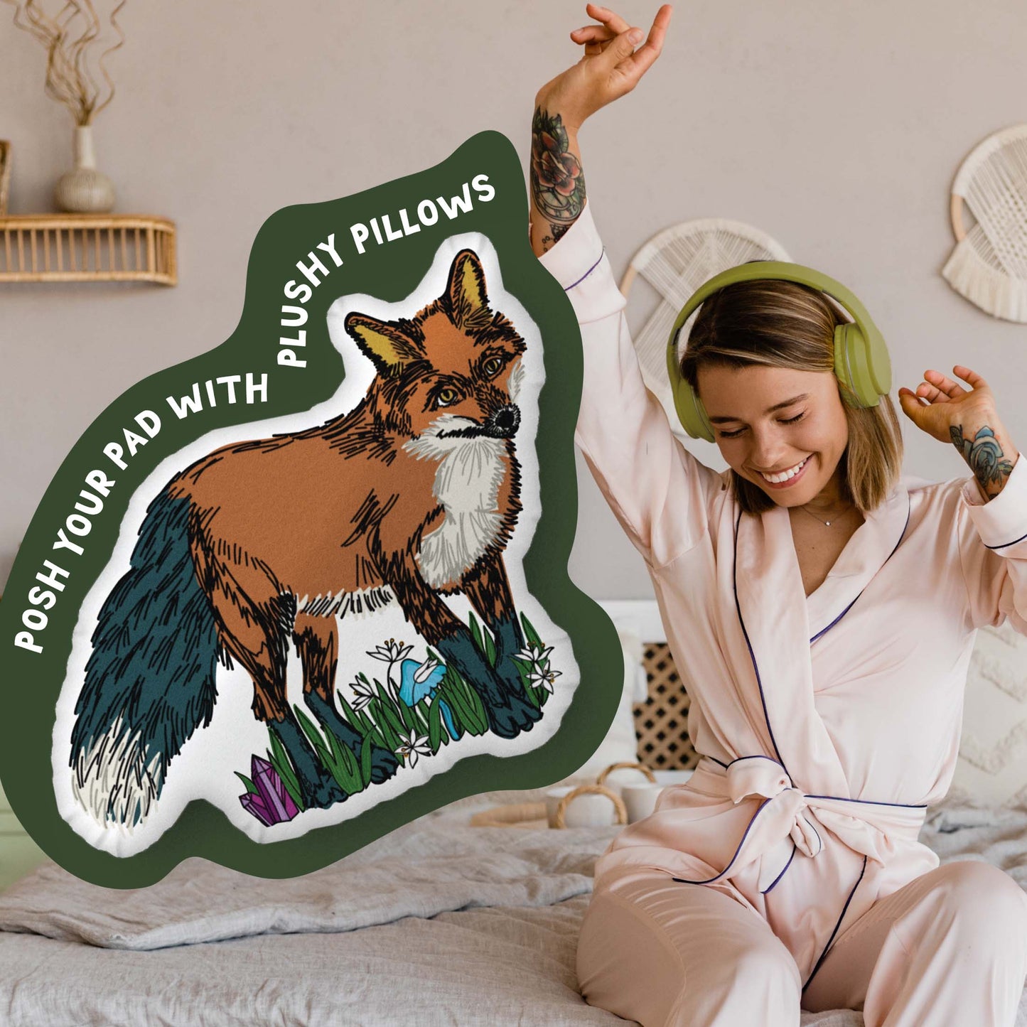 This image shows a photo of the fox-shaped pillow in a green organic shape. Inside the shape are the words "Posh your pad with plushy pillows". In the background, there is a photo of a woman in pajamas wearing headphones and sitting on a bed.