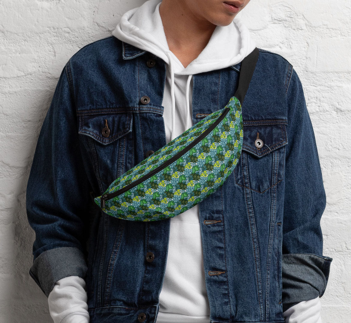 Pack worn in a sling bag style over a denim jacket and a white hoodie.