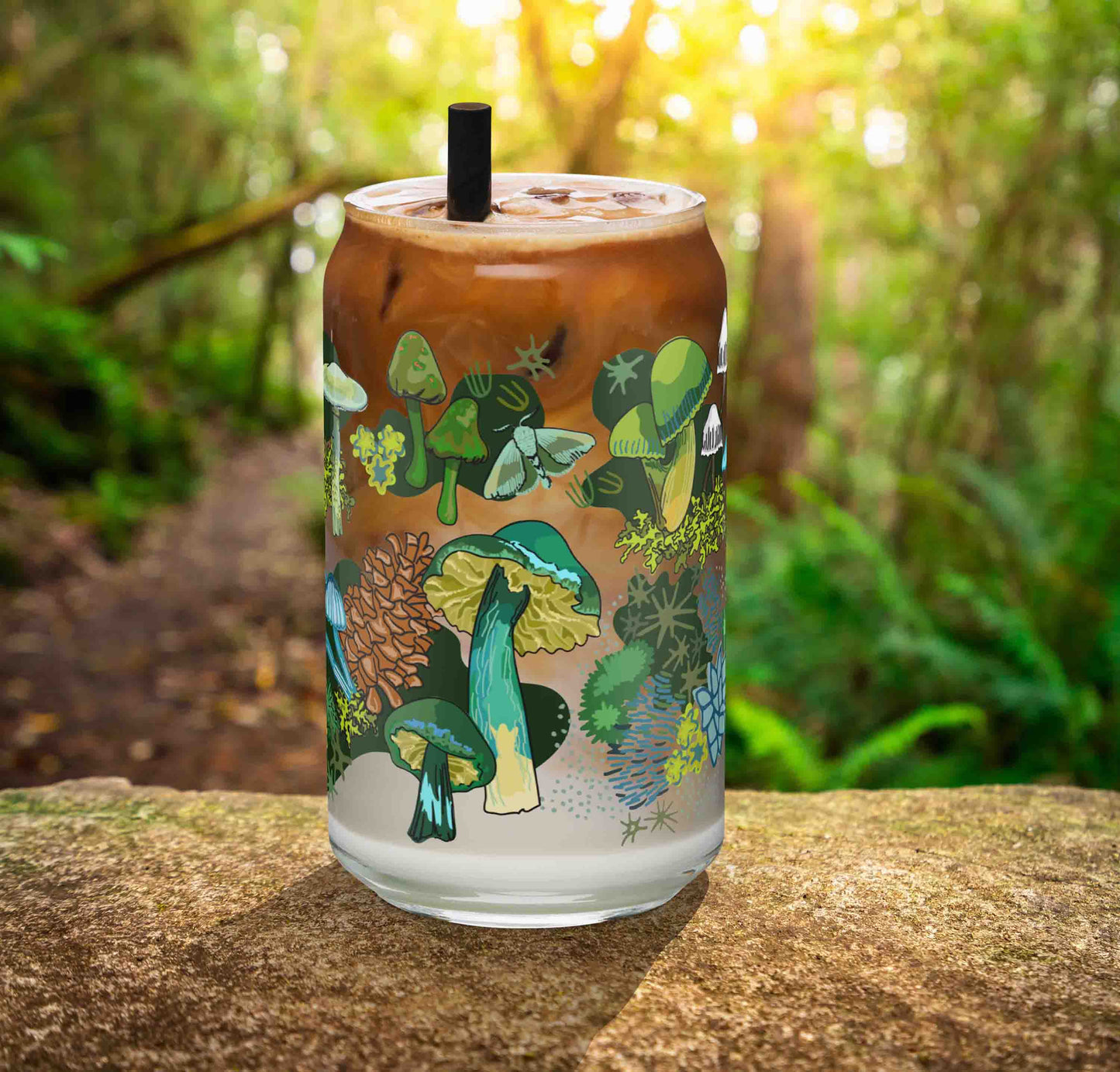 This is a photo of the Green Mushroom glass containing an iced latte. It's sitting on a rock in the woods.