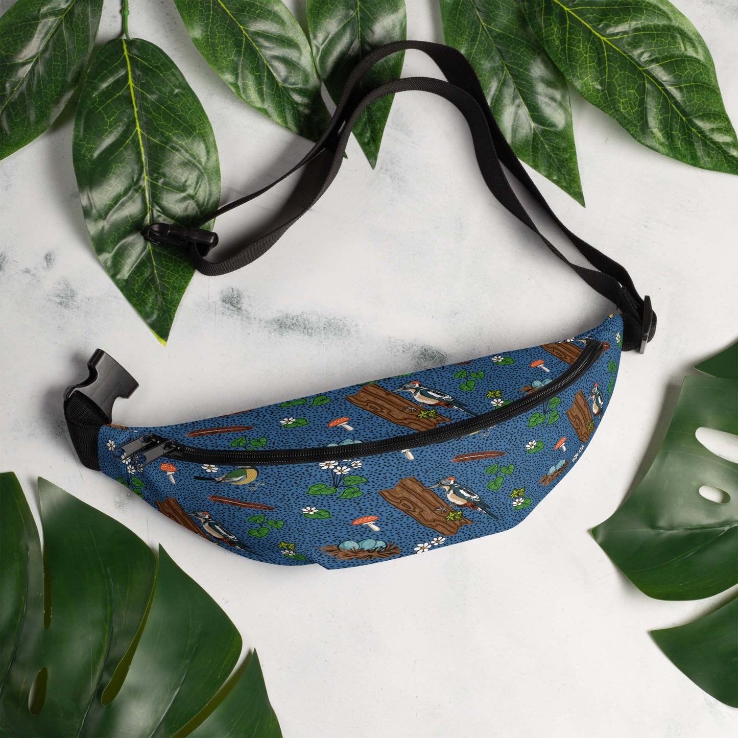 Bird hip pack on a marble table surrounded by leaves.