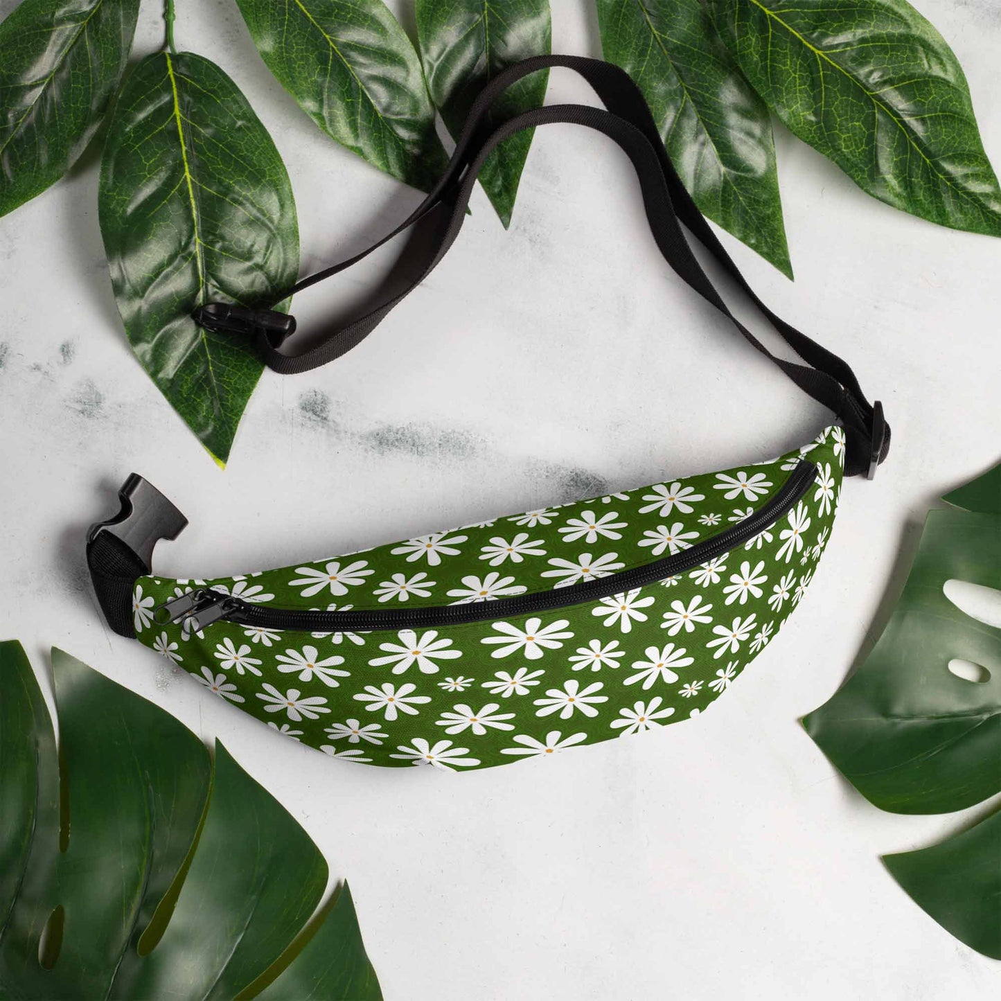 Hip pack laying on a marble table surrounded by leaves.