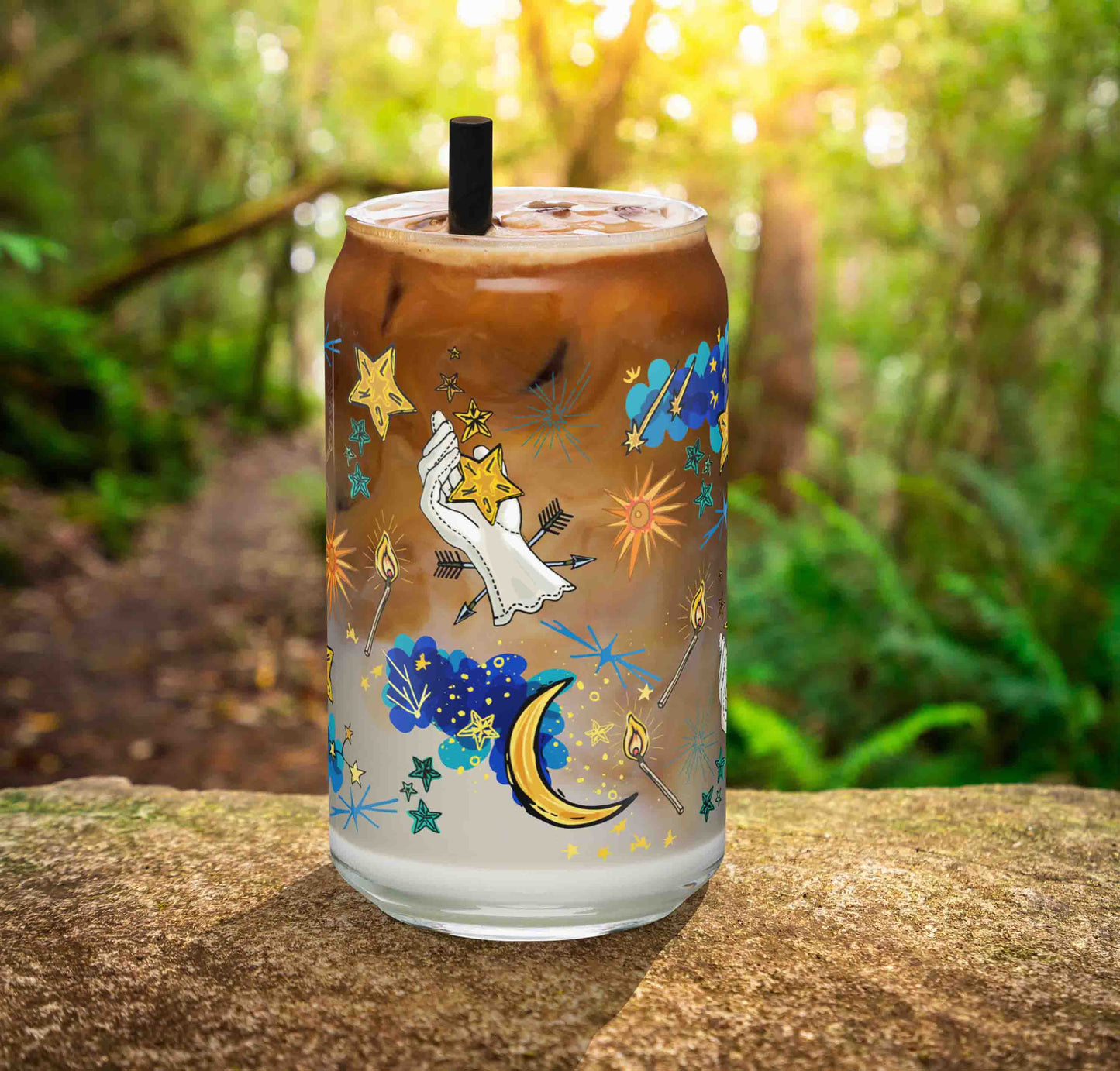 This is a photo of the glass containing an iced latte. It's sitting on a rock in the woods.