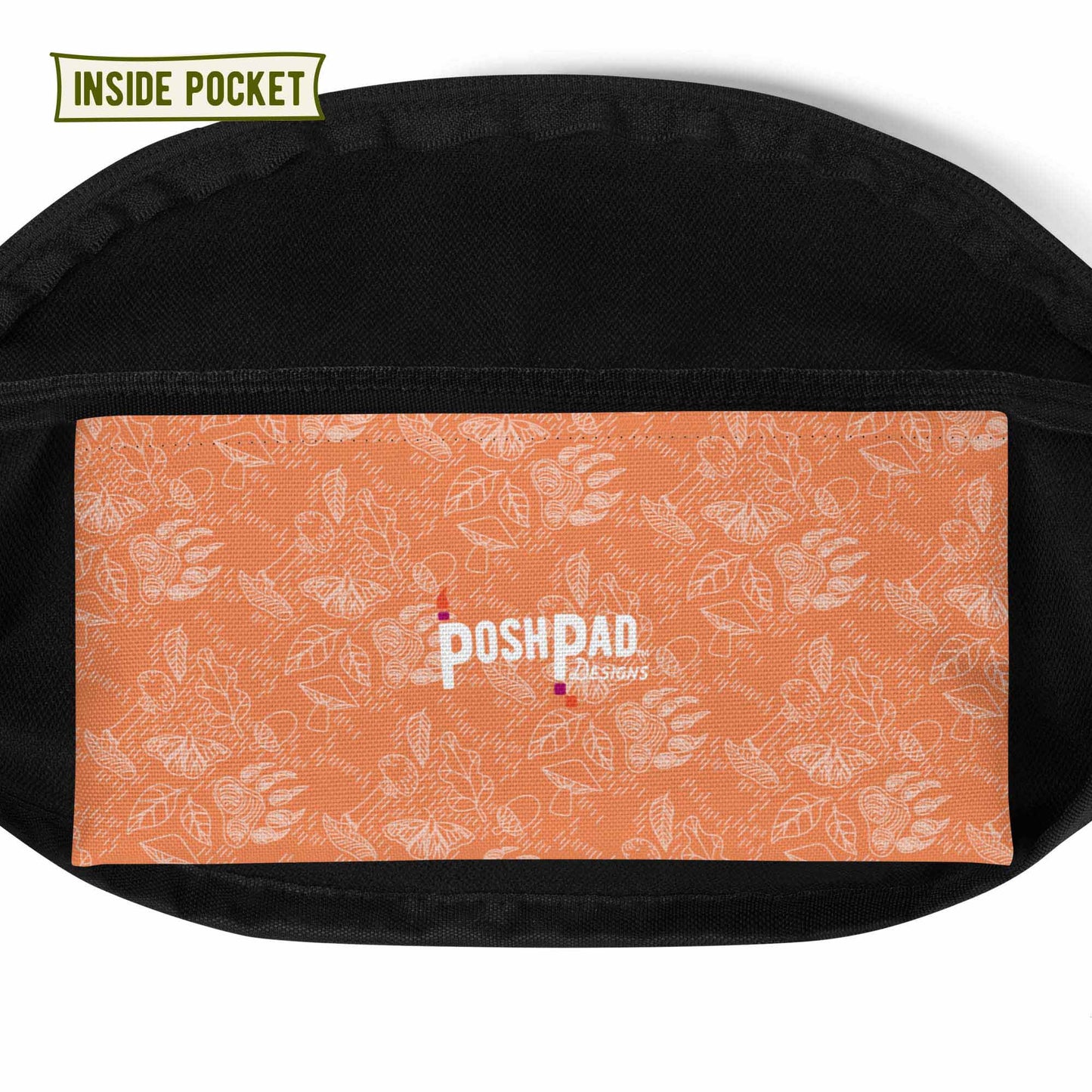 View of the inside pocket. It has a white pattern of bear paws, mushrooms, butterflies, and leaves on a green background. The Posh Pad logo is in the middle.