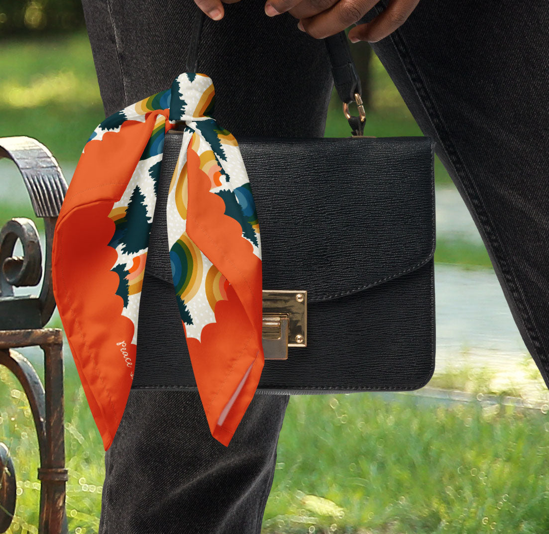 This is a photo of the Rainbow Pine Tree bandana scarf styled as a purse accessory.