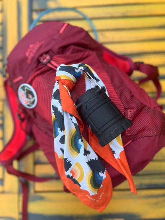 Rainbow bandana used to tie a camping lantern to a backpack.