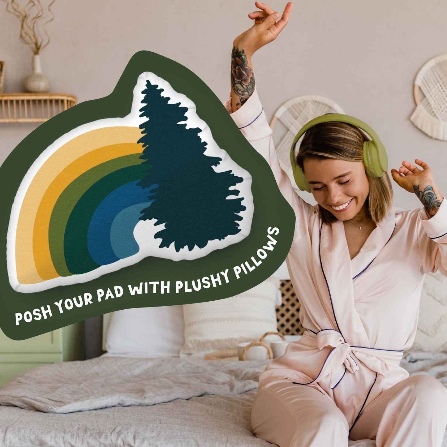 This image shows a photo of the rainbow-shaped pillow in a green organic shape. Inside the shape are the words "Posh your pad with plushy pillows". In the background, there is a photo of a woman in pajamas wearing headphones and sitting on a bed.