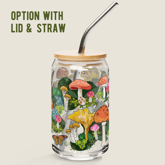 The Red Mushroom glass tumbler with the bamboo lid and metal straw option on an ivory background. The artwork on the glass is illustrations of various red, pink, and yellow mushrooms, green leaves, and moss, alongside yellow and red butterflies. The color palette is a mix of vibrant colors including red, pink, and yellow, with mossy greens.