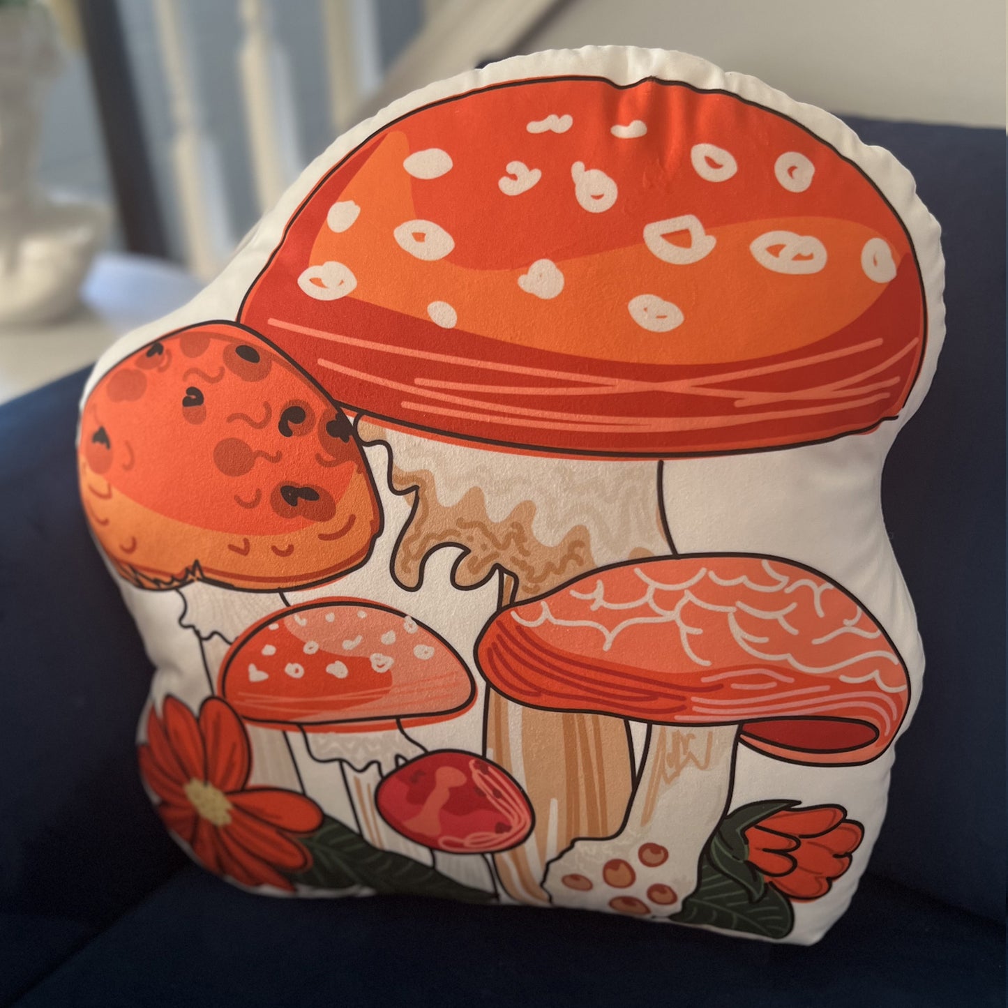 This is a photo of the red mushroom pillow sitting on a blue couch.