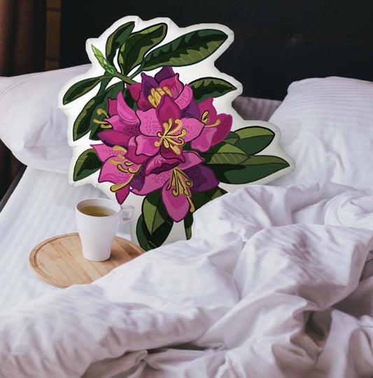 Rabbit-shaped pillow nestled in an unmade bed. There is a cup of coffee sitting on a wooden tray.