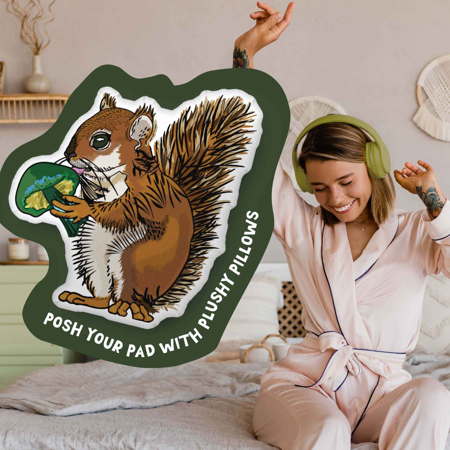 This image shows a photo of the squirrel-shaped pillow in a green organic shape. Inside the shape are the words "Posh your pad with plushy pillows". In the background, there is a photo of a woman in pajamas wearing headphones and sitting on a bed.