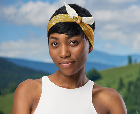 This is an image of a woman wearing the bandana as a headband. There is a mountain view behind her.