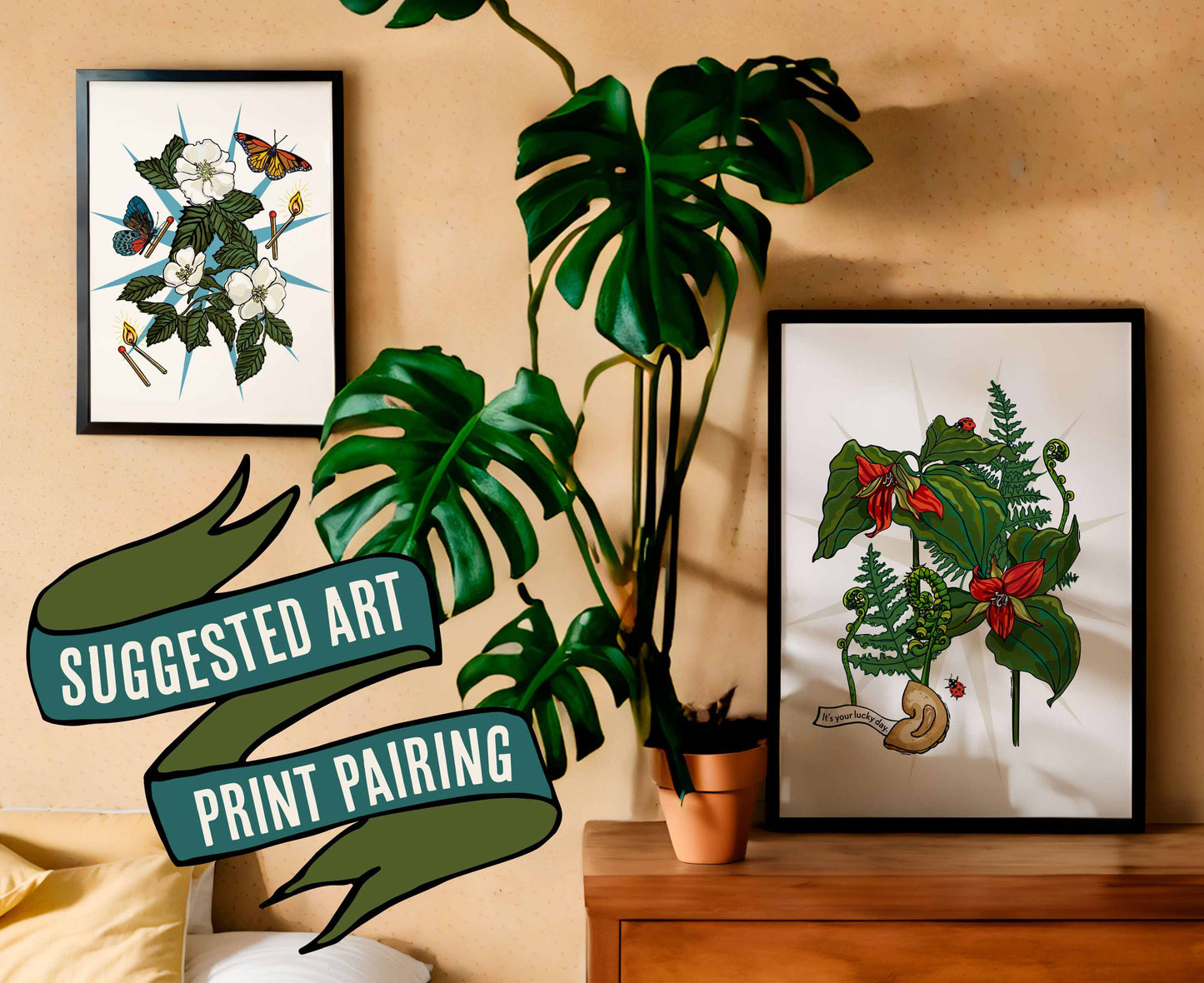 This photo shows a suggested art print pairing. This pairing shows the red trillium art print in a black frame on a dresser with a plant. The companion print is the wild white roses with butterflies art print, which is in a black frame on the wall.