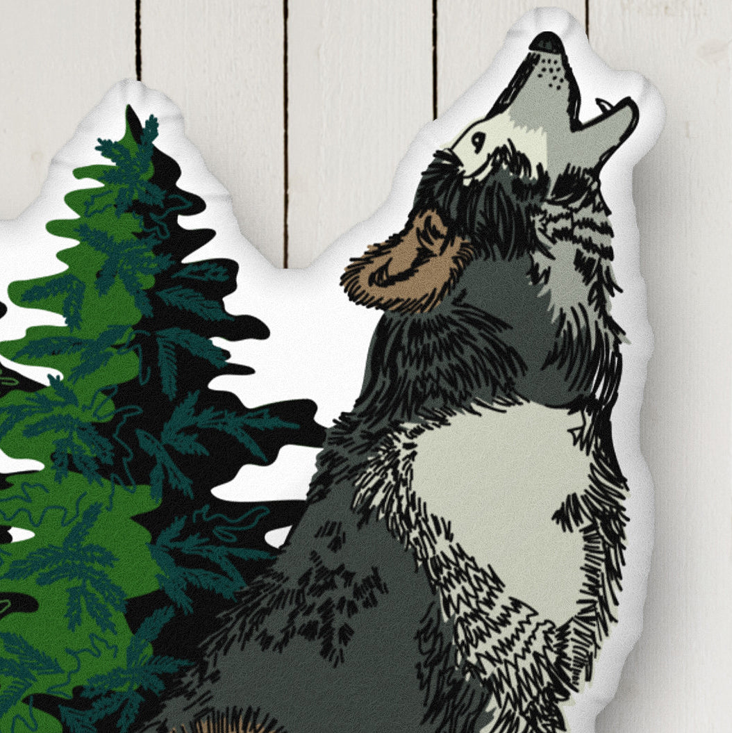 This is a close-up image of the wolf pillow on a white wood background.