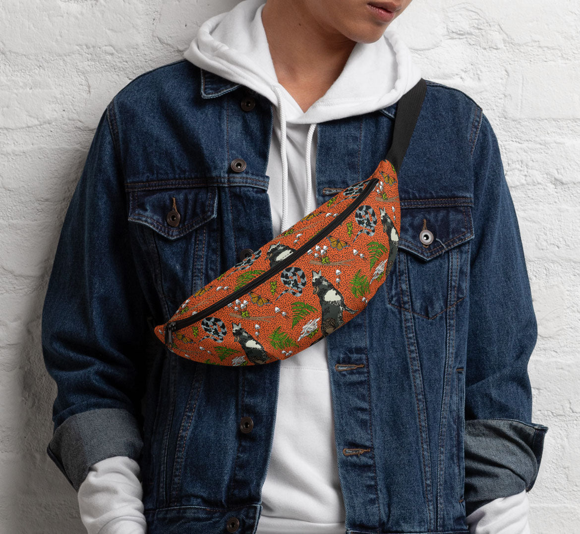 Pack worn in a sling bag style over a denim jacket and a white hoodie.