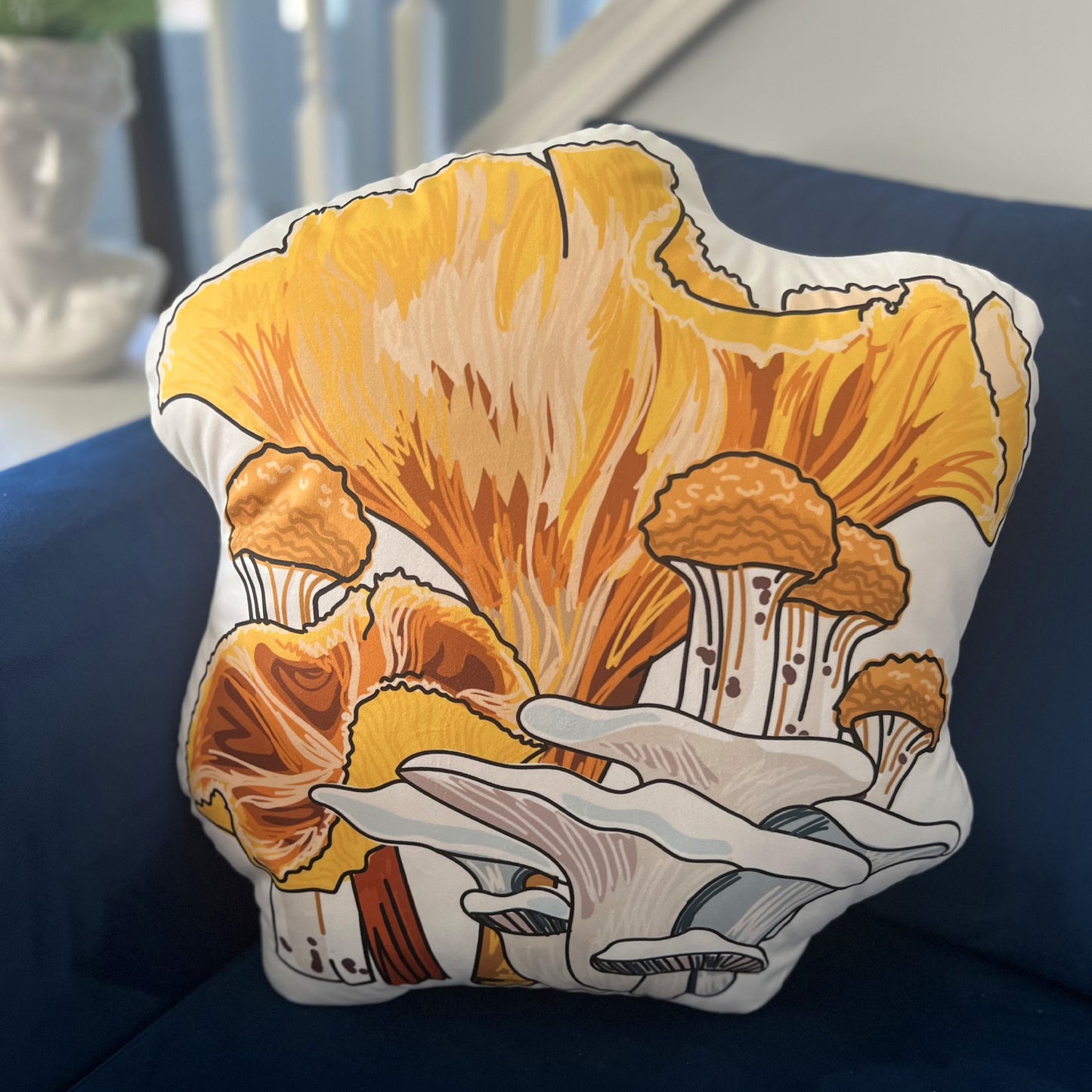 This is a photo of the yellow mushroom pillow sitting on a blue couch.