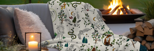 A cozy sherpa blanket on an outdoor couch by a firepit.