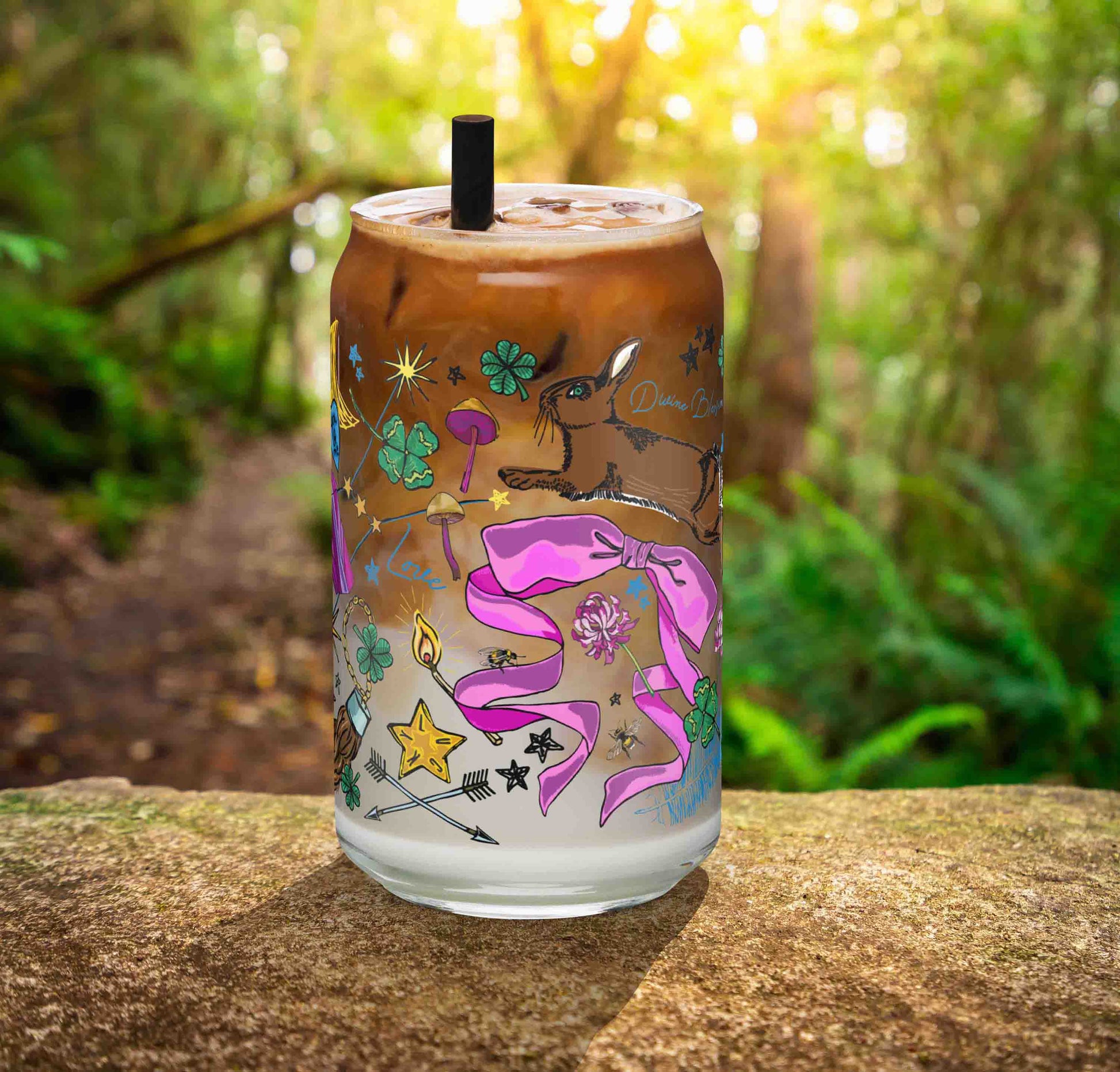 This is a photo of the glass containing an iced latte. It's sitting on a rock in the woods.