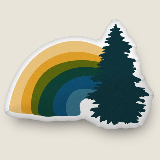 Rainbow-shaped pillow on an ivory background.
