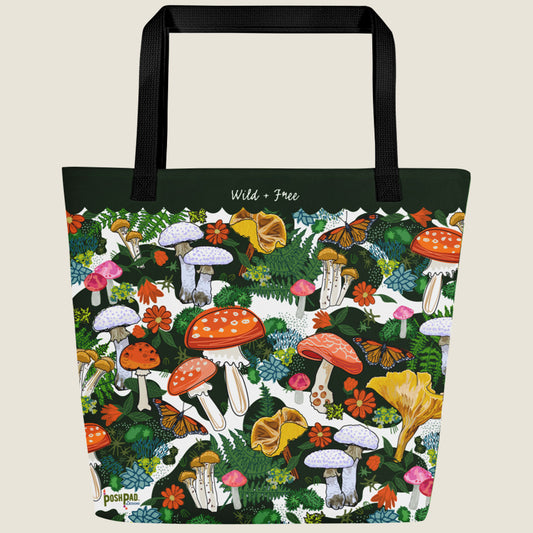 Red mushroom-themed oversize tote with large interior pocket. This design has red, yellow, white, and pink mushrooms, moss, ferns, red flowers, and butterflies. The words "Wild + Free" are written in the green border at the top.