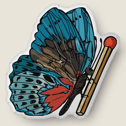 Butterfly and match-shaped pillow on an ivory background.
