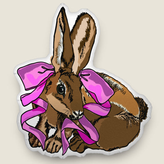 Rabbit-shaped pillow on an ivory background.