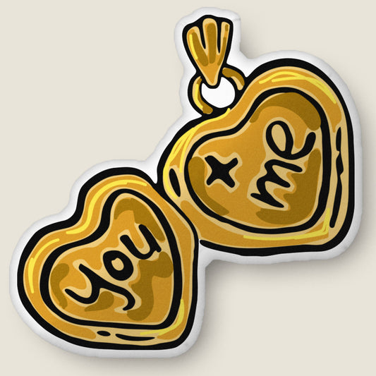 You + Me Locket-shaped pillow on an ivory background.