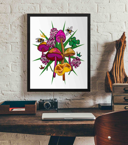This photo shows the framed Queen's Favor art print hanging on a white brick wall. Below it, there is a wood. The desk has a camera, laptop, and wood sculpture on it.