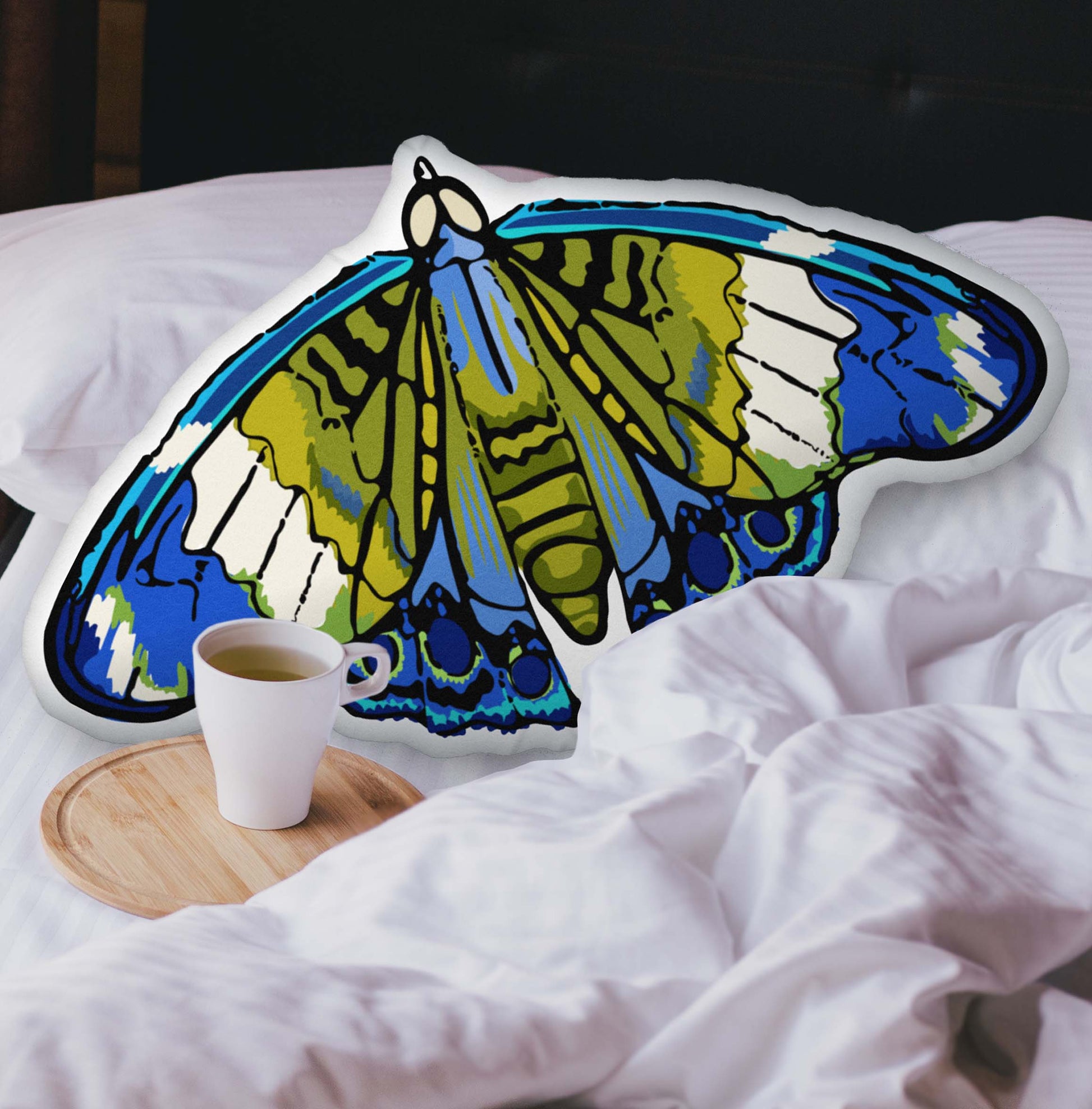 A velvety Blue and Green Bohemian Moth-shaped pillow nestled into a cozy, layered bed. The plush texture and hand-drawn bohemian details add a warm, nature-inspired touch to your space.