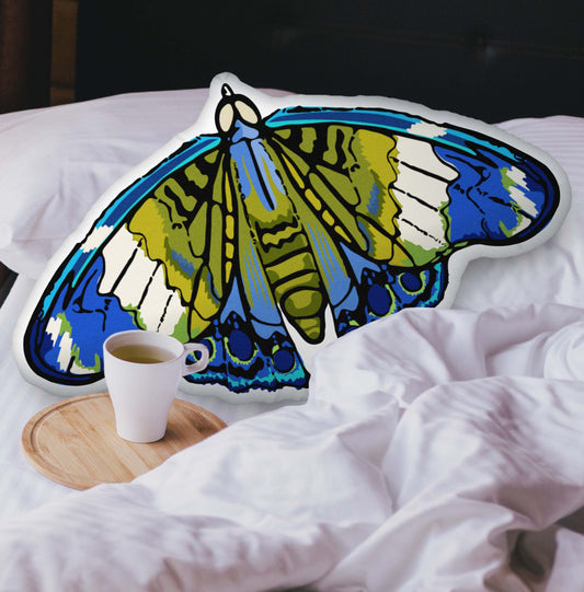 A velvety Blue and Green Bohemian Moth-shaped pillow nestled into a cozy, layered bed. The plush texture and hand-drawn bohemian details add a warm, nature-inspired touch to your space.