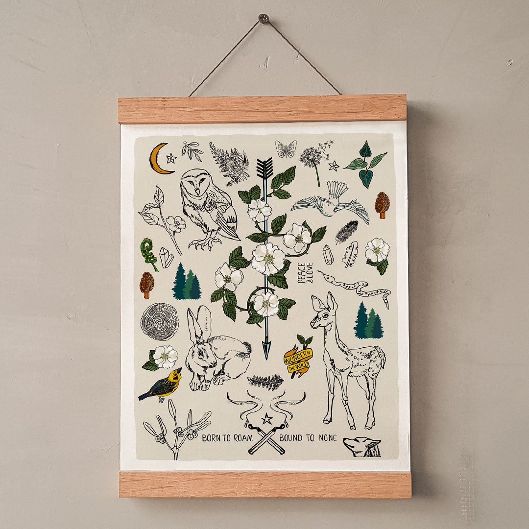 Born to Roam art print poster hung in a wood wall hanger. The artwork has drawings of wild roses, an owl, deer, rabbit, wolf, a crescent moon, ferns, crystals, mushrooms, dandelions, burning matches, and forest icons.