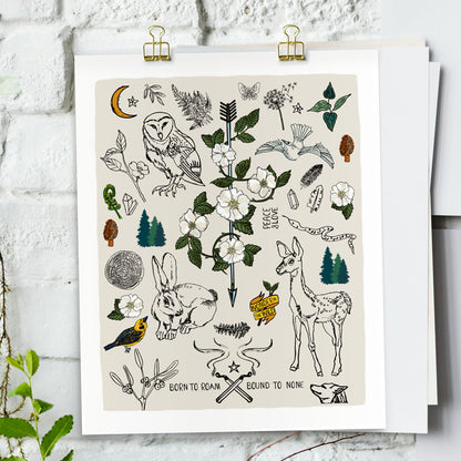 Born to Roam art print poster hung with gold clips on a white brick wall. The artwork has drawings of wild roses, an owl, deer, rabbit, wolf, a crescent moon, ferns, crystals, mushrooms, dandelions, burning matches, and forest icons.