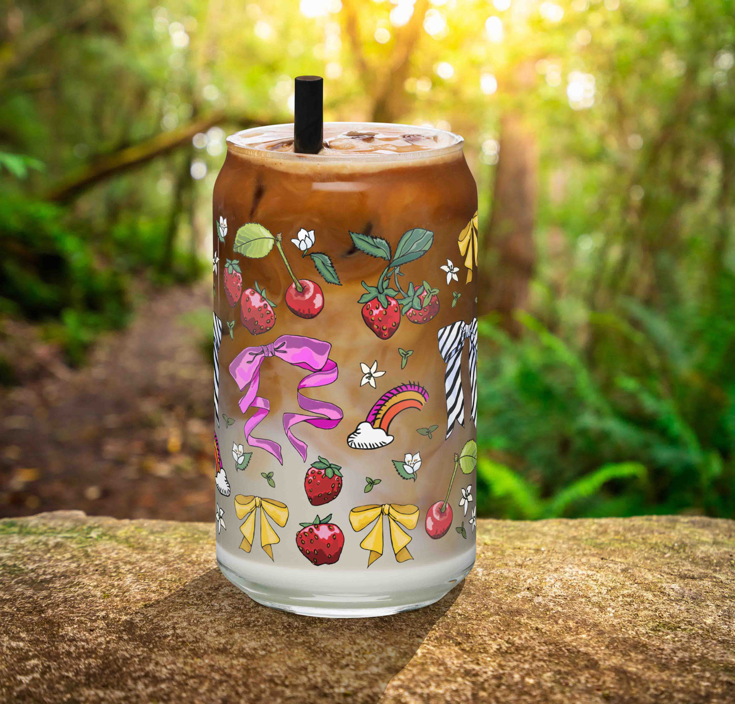This is a photo of the glass containing an iced latte. It's sitting on a rock in the woods.