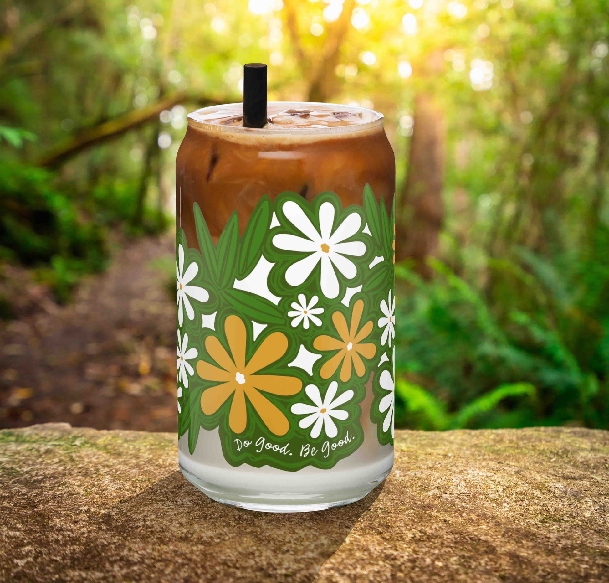 This is a photo of the glass containing an iced latte. It's sitting on a rock in the woods.