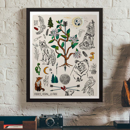 Fierce, Feral, and Free art print poster in a black wood frame hanging on a brick wall, above a vintage desk.