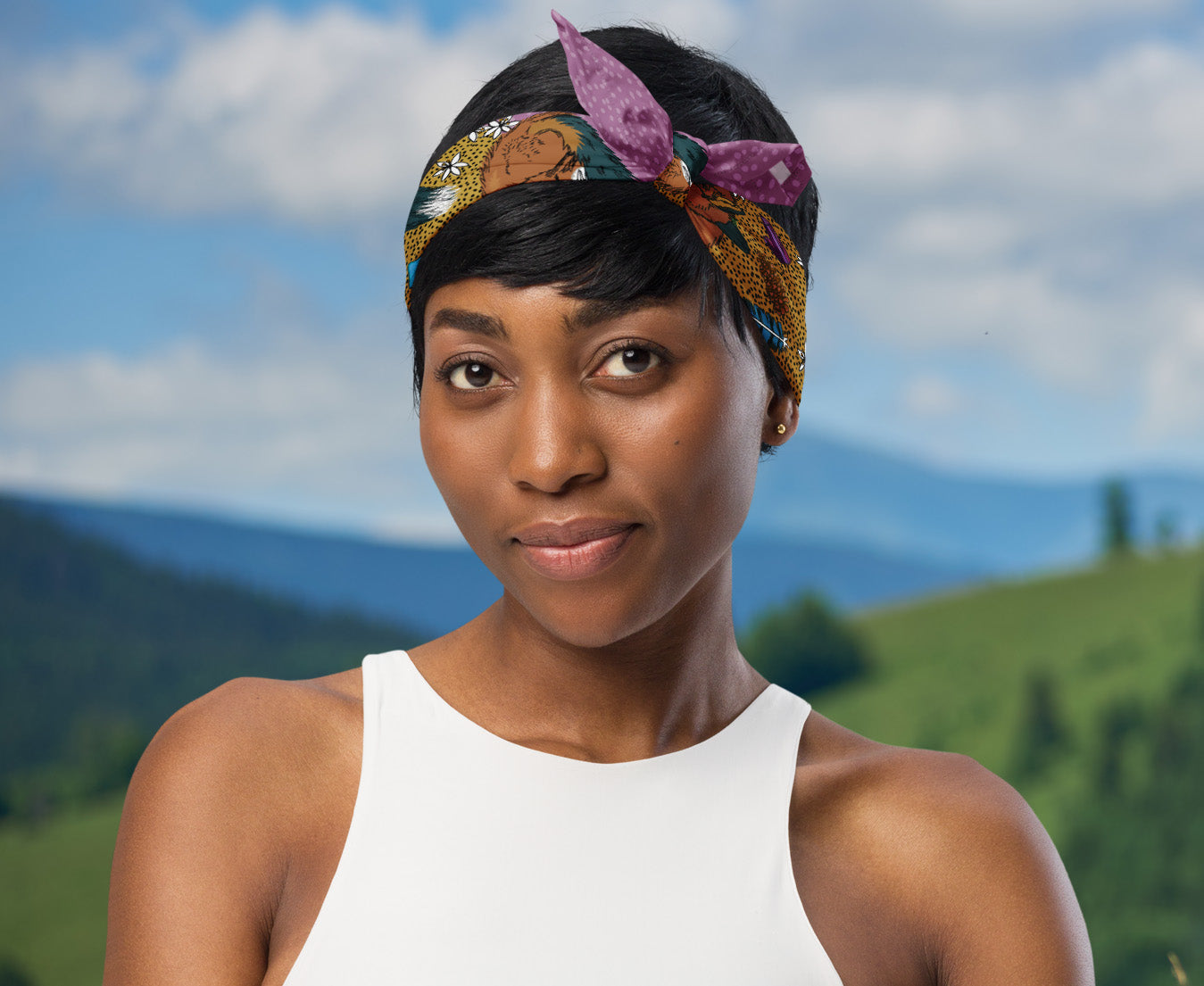 This is an image of a woman wearing the fox and flower around her head in a headscarf boho style. There is a mountain range in the background.
