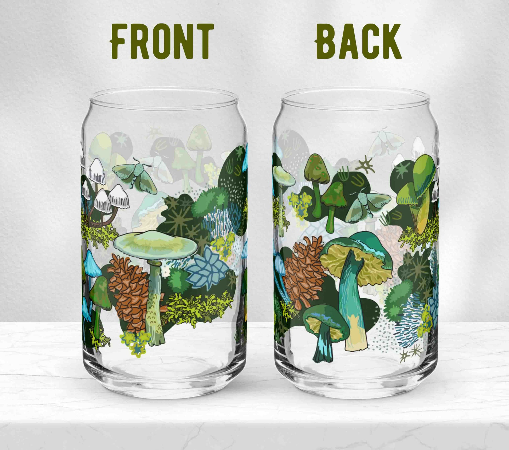 Two glasses sitting on marble. Each one is turned in a different direction to show the front and the back of the design. The artwork is a mix of vasrous green, blue, and white mushrooms, moths, pinecones, and moss.