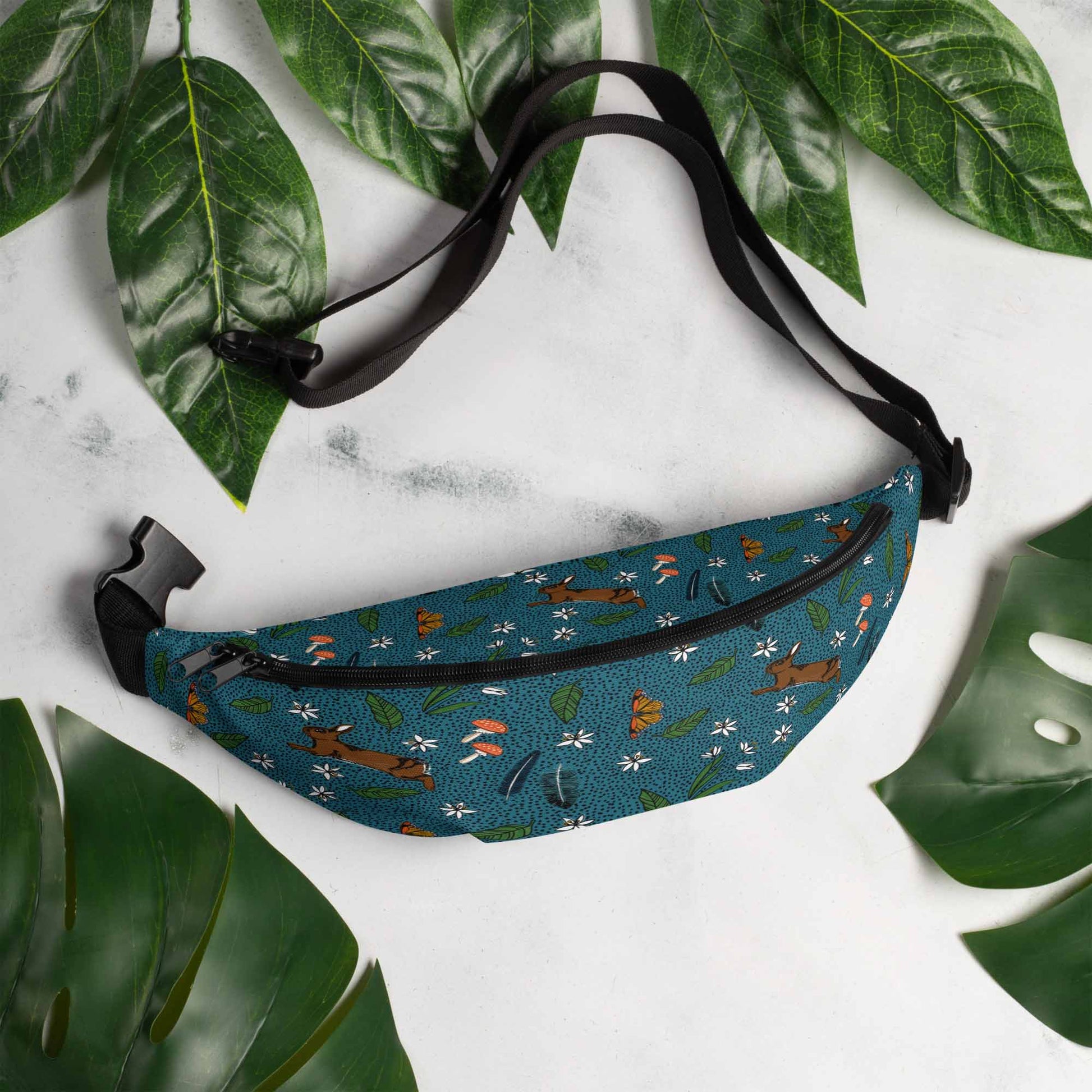 Rabbit meadow hip pack on a marble table surrounded by leaves.