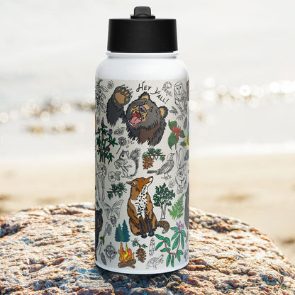 Photo showing the right side of the Mountain Hikes Insulated Water Bottle with Straw Lid as it sits on a rock beside  a lake.