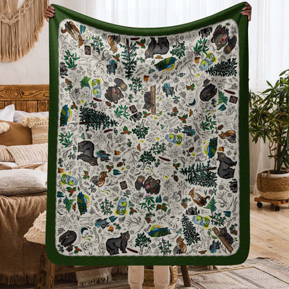 This image shows the size. It's a person holding up the Mountain Adventures sherpa blanket in a cozy boho-style apartment.